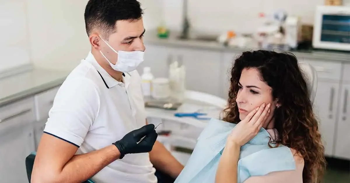 Dentist explaining broken tooth treatment options to a patient