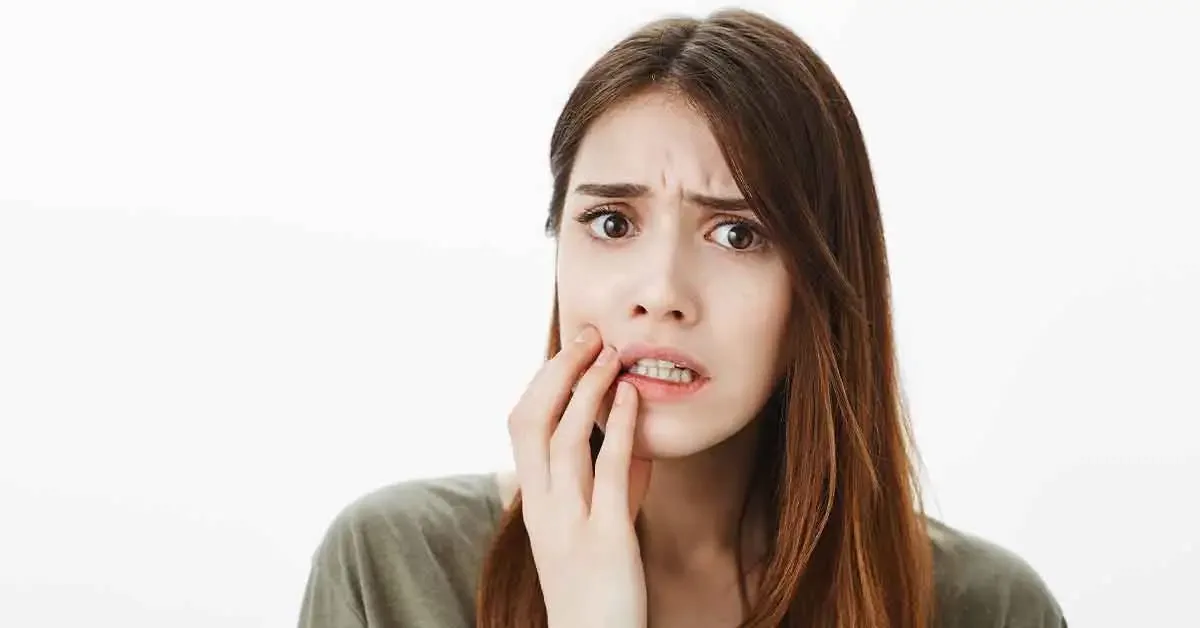 Patient holding jaw after breaking a tooth during an urgent dental situation