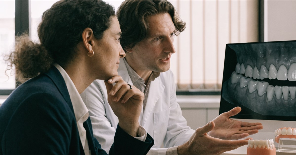 International patient reviewing fixed and removable tooth replacement options with a dentist