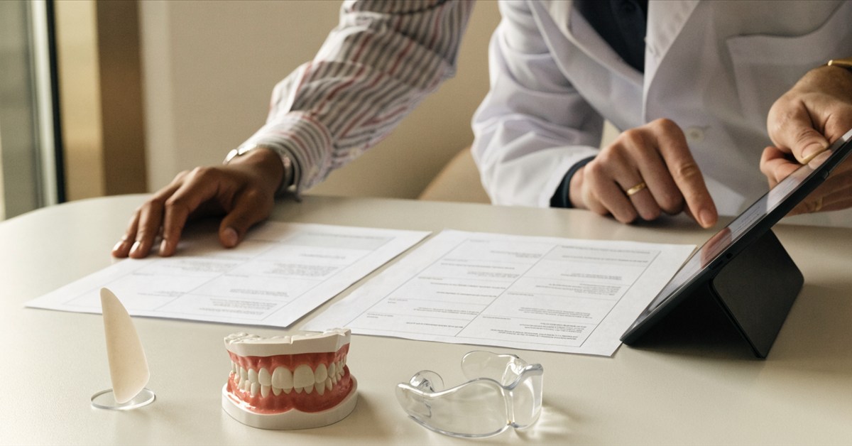 Dentist and patient comparing itemized veneer treatment plans during a consultation