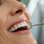 Dentist inspecting natural-looking ceramic veneers during a long-term maintenance visit