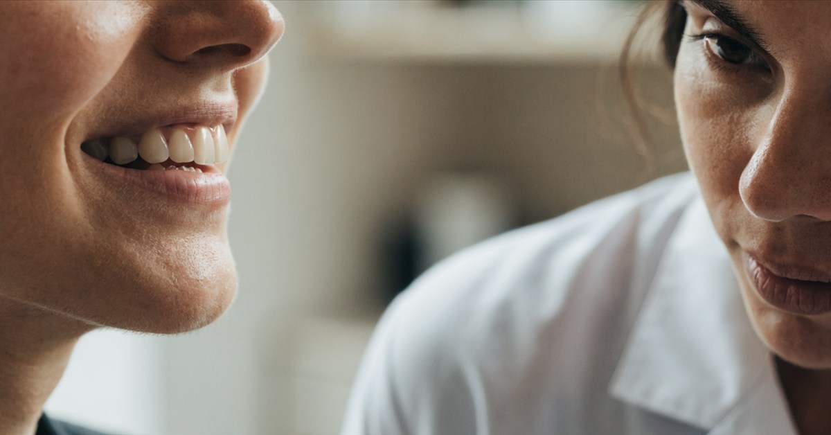 Dentist assessing the teeth visible in a patient's natural smile before planning veneer count