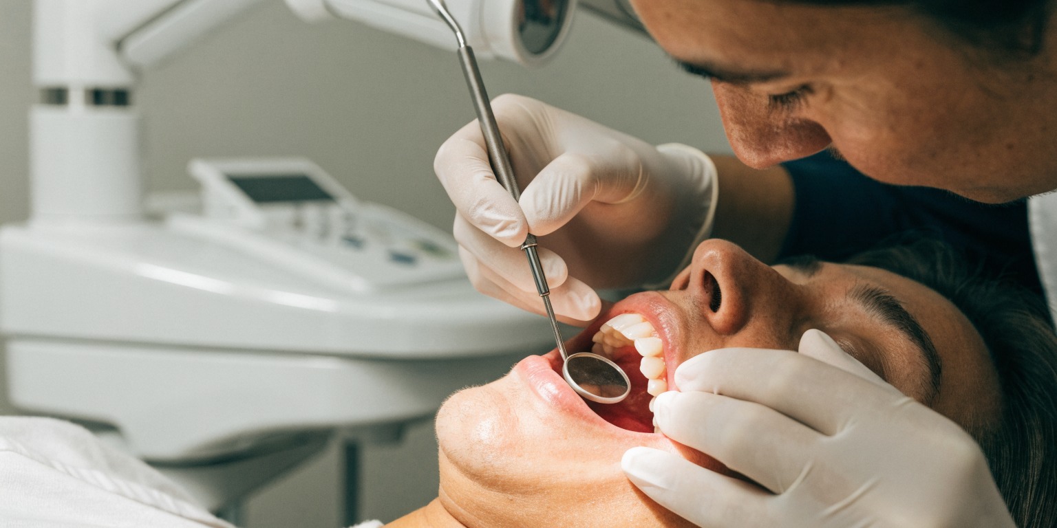 Dentist gently examining the gums around an implant-supported tooth