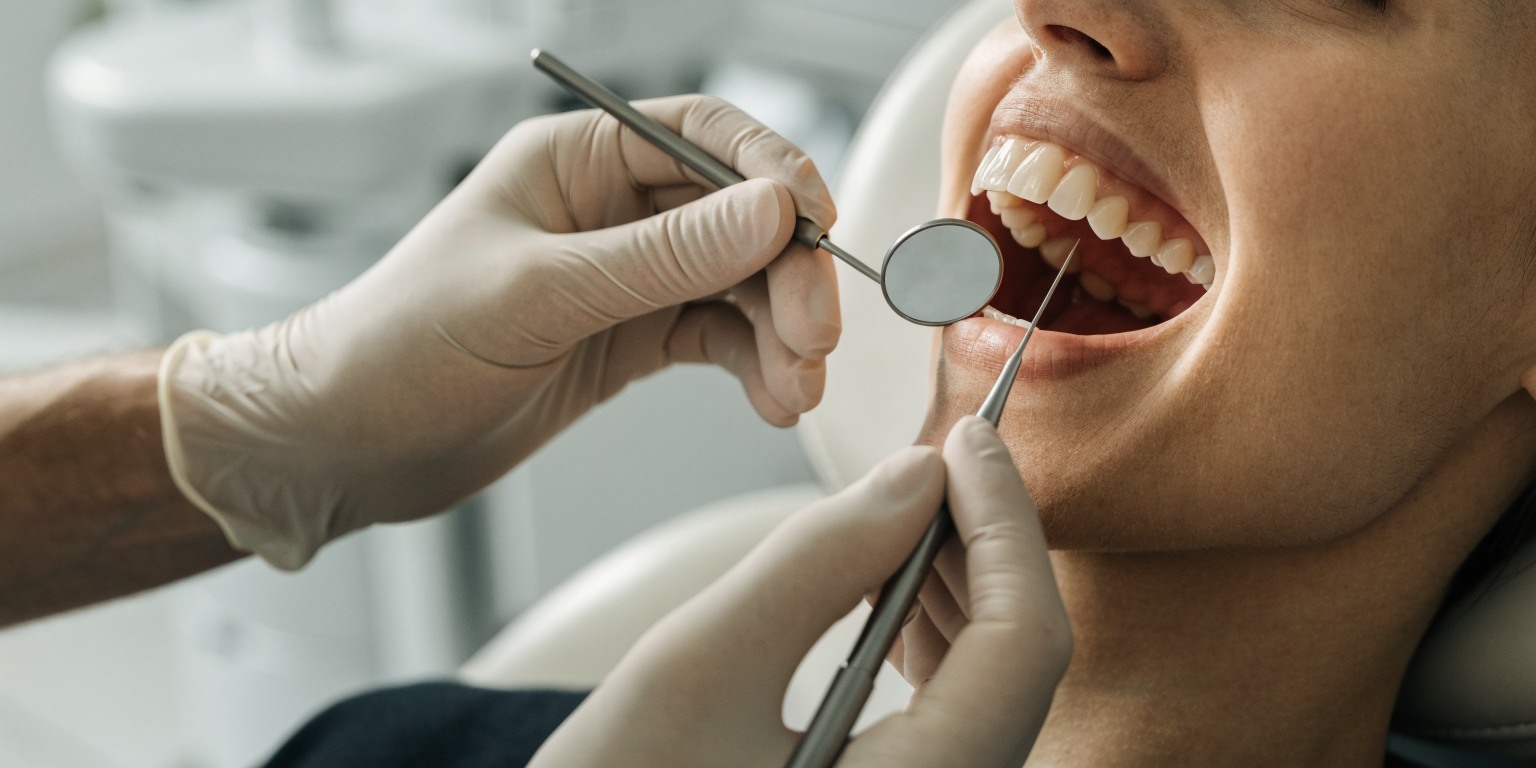 Dental professional checking gum health around an implant during a maintenance visit