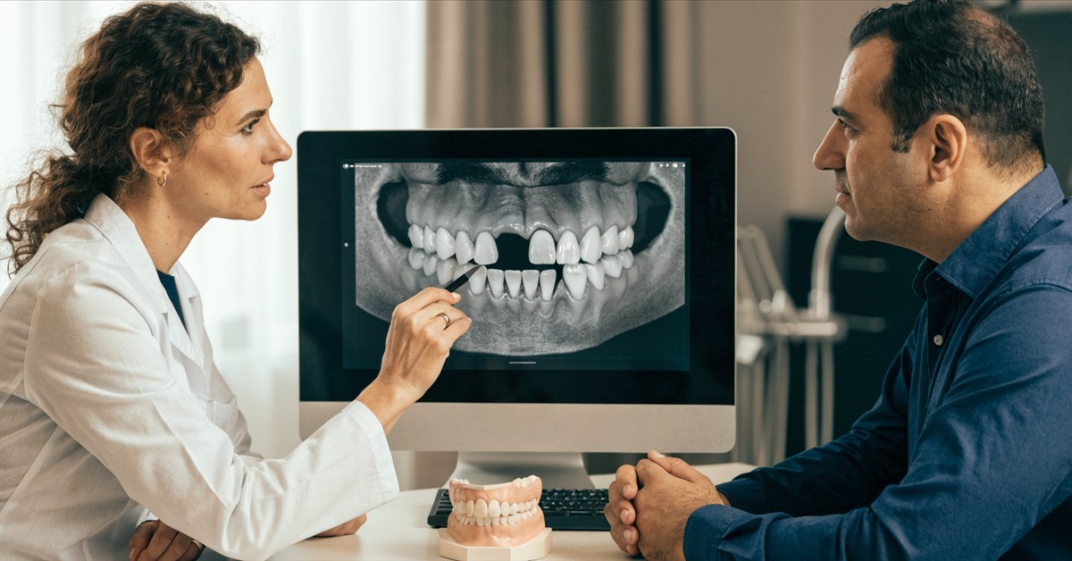 Dentist assessing bone and neighboring teeth for a single-tooth implant