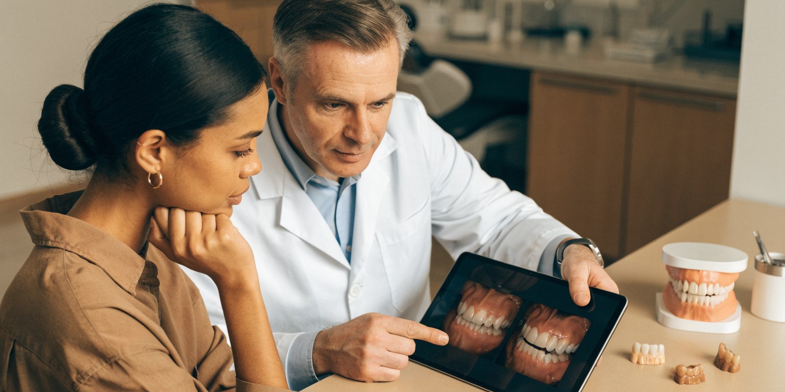 Patient reviewing contextual before-and-after dental cases with a dentist