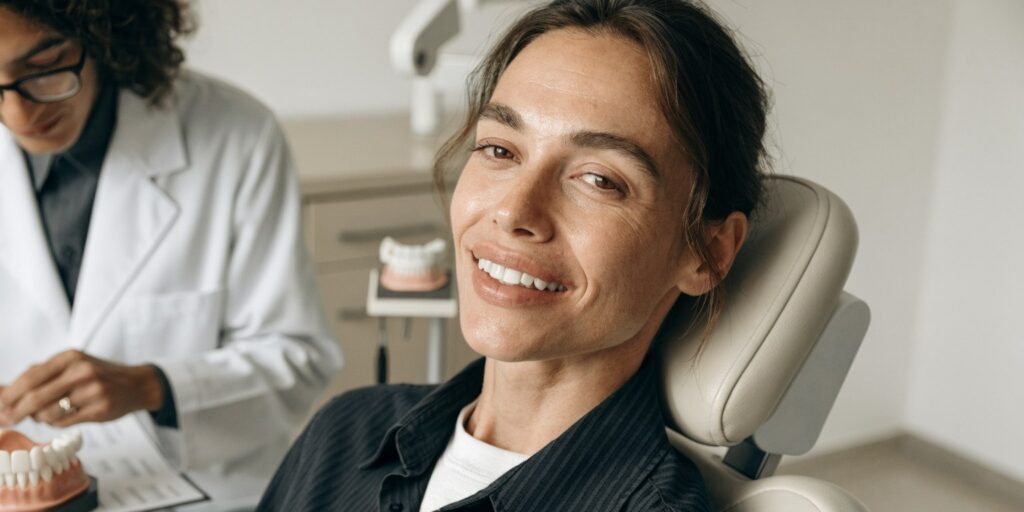 Dentist reviewing long-term Hollywood Smile restorations, gums and bite during follow-up