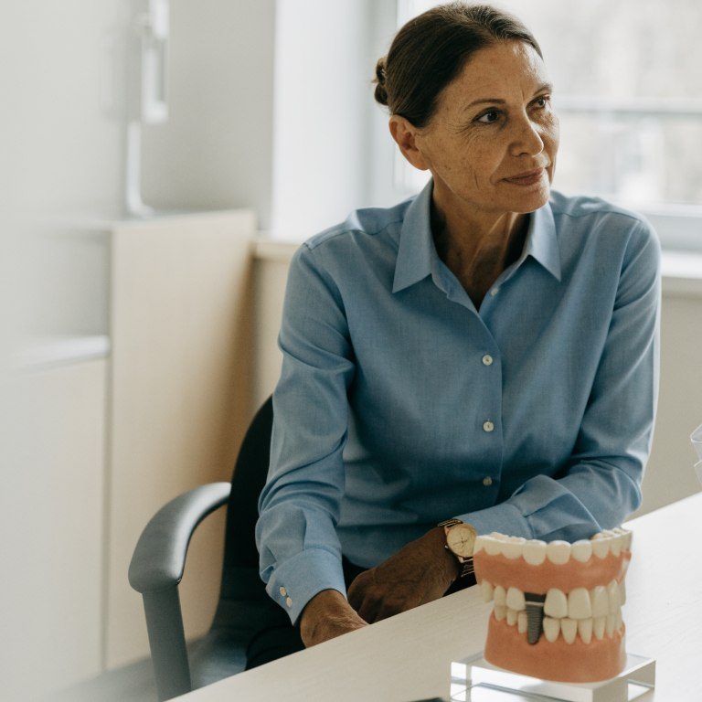 Adult patient discussing long-term dental implant care with a dentist