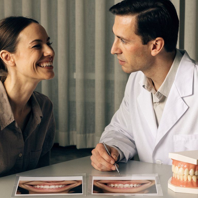 Dentist assessing visible teeth and smile width to plan how many teeth need Hollywood Smile treatment