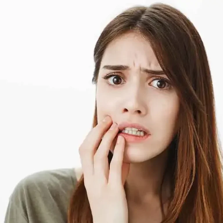 Patient holding jaw after breaking a tooth during an urgent dental situation